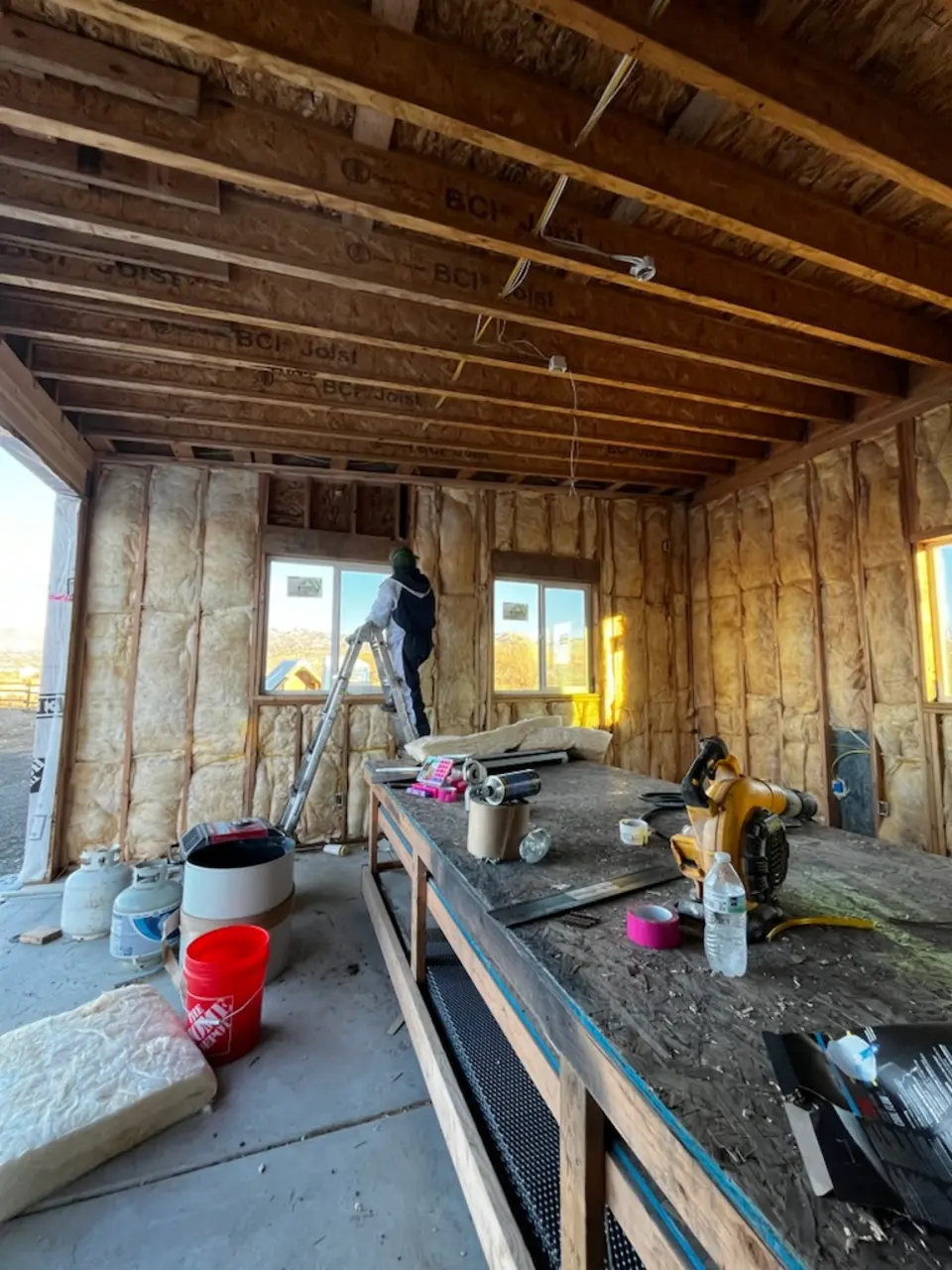 The same framed room with fiberglass batt insulation fitted between every wall stud